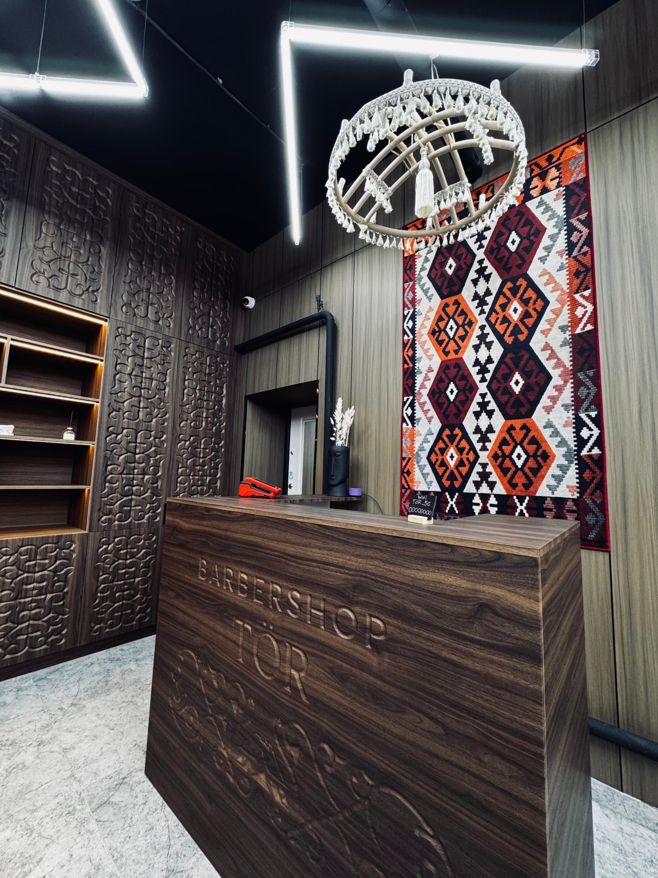 Деревянная стойка с гравировкой Barbershop Tör и ковёр-килим на стене